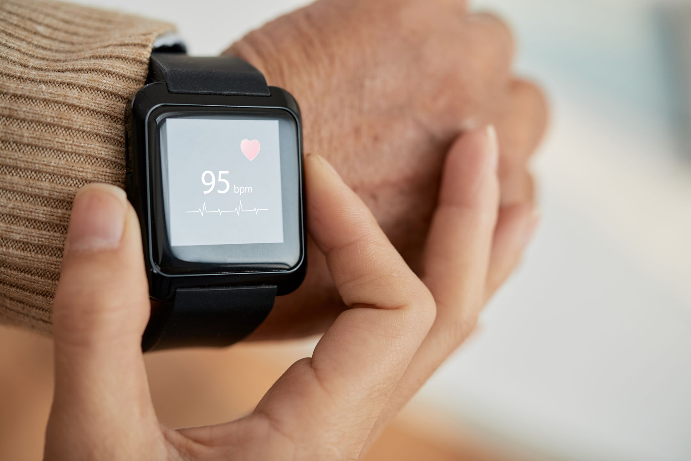 Smartwatch displaying heart rate of 95 bpm with ECG line and heart icon.
